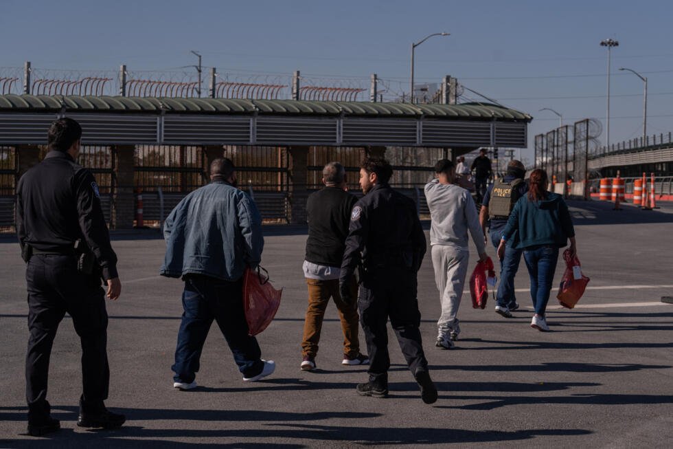 Un groupe de migrants escorté par des agents de l'ICE en vue de leur expulsion, à McAllen, au Texas, le 13 mars 2026.