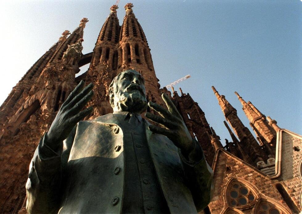 Un buste représentant l'artiste moderniste Antonio Gaudi devant la façade de la Nativité de la basilique de la Sagrada Familia, à Barcelone.