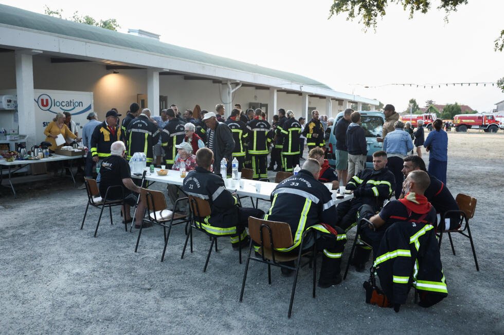 En images : près du bassin d'Arcachon, le feu s'attaque à nouveau à la forêt des Landes 3 Les pompiers prennent leur petit-déjeuner devant la salle des fêtes Gérard Blanc au Porge, le 23 juillet 2026.
