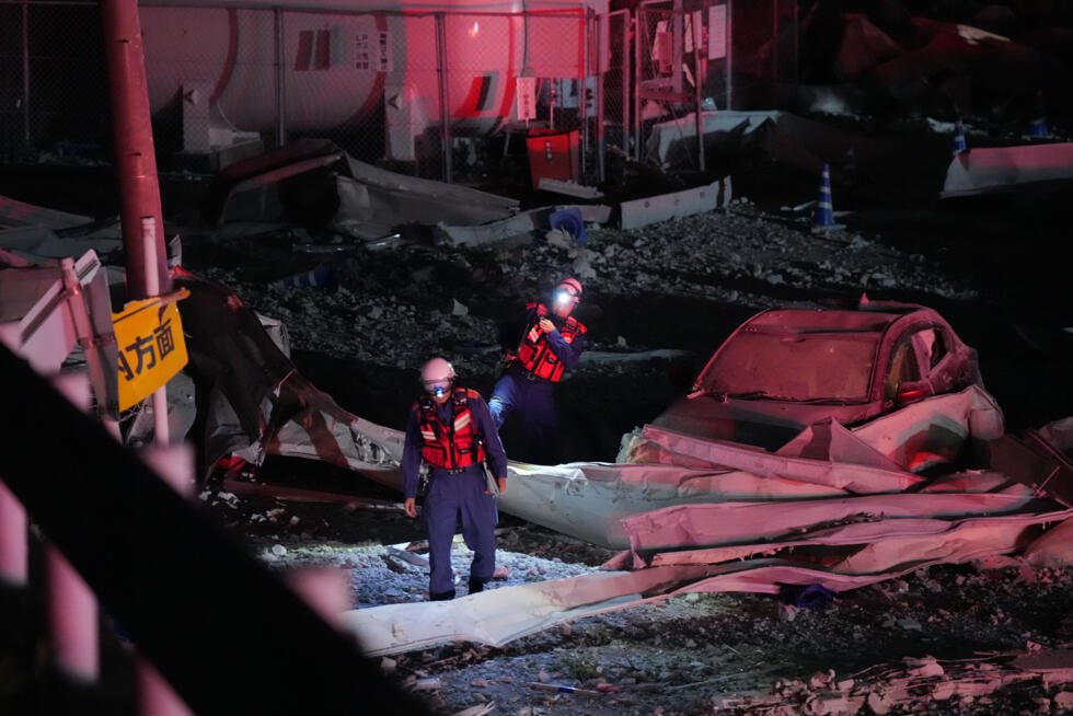 Des pompiers traversent le parking de l'AEON Mall Kumamoto à la suite d'une explosion survenue dans la ville de Kashima, dans la préfecture de Kumamoto, au Japon.